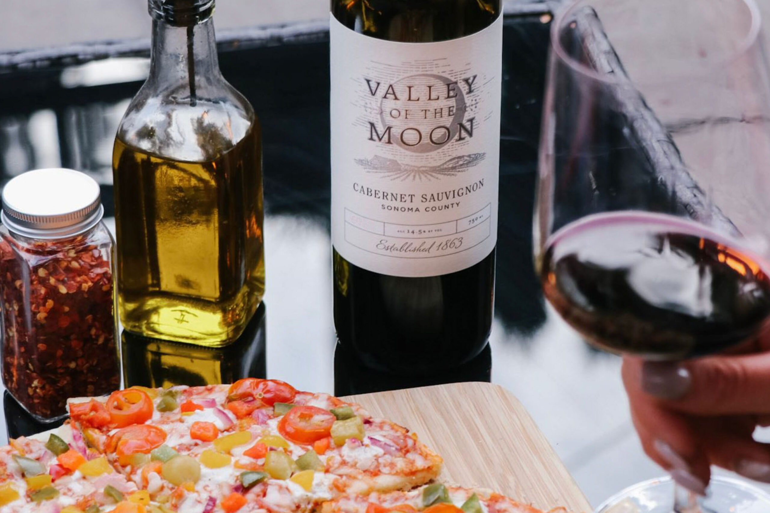 Valley of the Moon Cabernet Sauvignon Bottle shot with a plate of PIzza and glass of wine